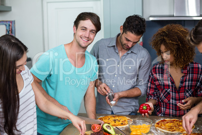 Young friends preparing pizza at home