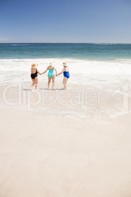 Senior woman friends running into water