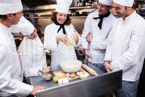 Head chef teaching his team to prepare a dough