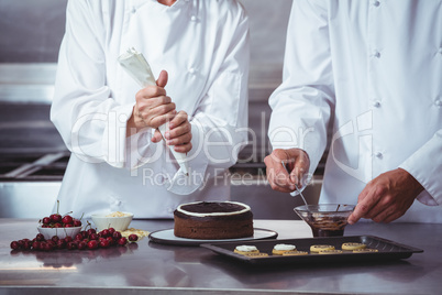 Chefs decorating a cake