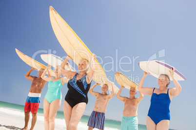 Senior friends holding surfboard