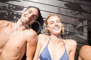Smiling couple relaxing on wooden deck