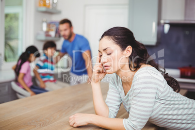 Tensed mother at table with family