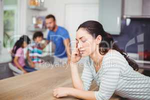Tensed mother at table with family