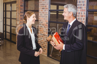 Male lawyer smiling while discussing with female colleague