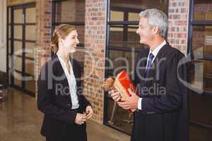 Male lawyer smiling while discussing with female colleague