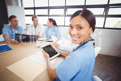 Portrait of female doctor holding digital tablet in conference r