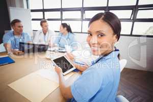 Portrait of female doctor holding digital tablet in conference r