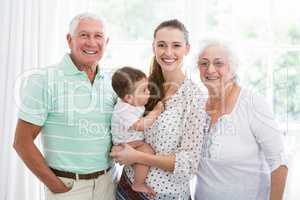 Portrait of smiling grandparents and mother with baby