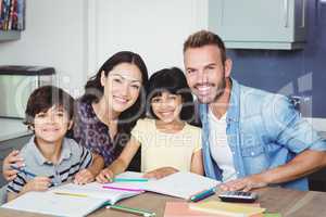 Portrait of happy parents assisting children