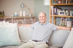 Portrait of happy senior man sitting at home