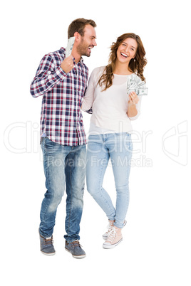 Happy young couple holding fanned out currency notes