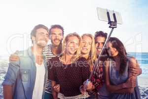 Happy friends taking selfie with selfie stick