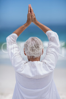 Rear view of mature woman posing with hands joined