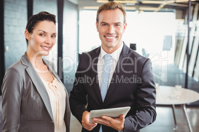 Portrait of businessman and businesswoman holding digital tablet