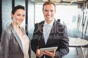 Portrait of businessman and businesswoman holding digital tablet