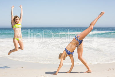 Two women jumping on the beach