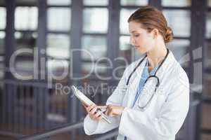 Female doctor holding clipboard while working