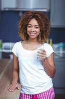 Portrait of smiling young woman holding glass of milk