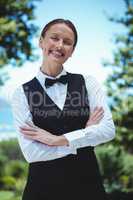Smiling waitress posing with crossed arms