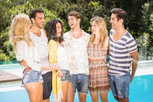 Group of friends talking near pool