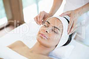 Close-up of beautiful woman receiving facial massage