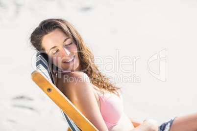 Happy woman sitting on an armchair with eyes closed