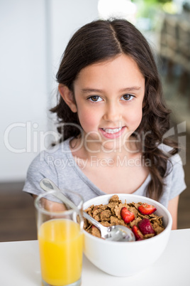 Smiling girl having breakfast