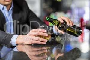 Businessman pouring whisky in glass