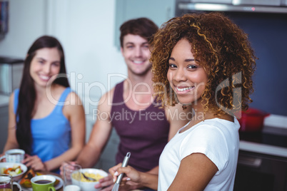 Smiling friends standing at table