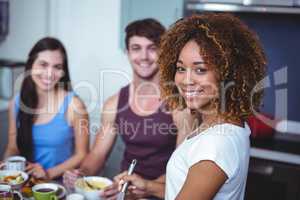 Smiling friends standing at table