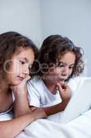 Brother and sister using digital tablet