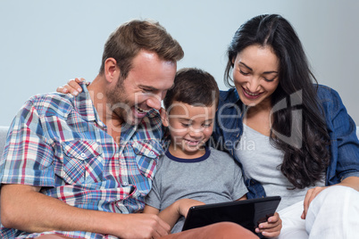 Mother, father and son looking at digital tablet