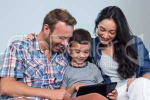 Mother, father and son looking at digital tablet