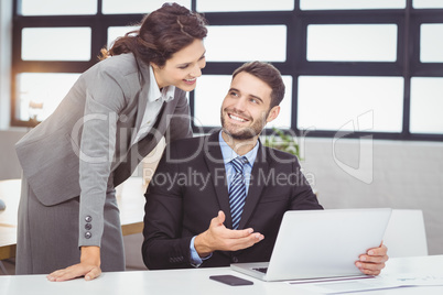 Young business people discussing over laptop