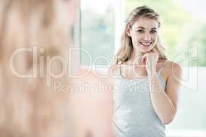 Smiling young woman looking in mirror