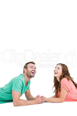 Happy young couple lying on floor looking up