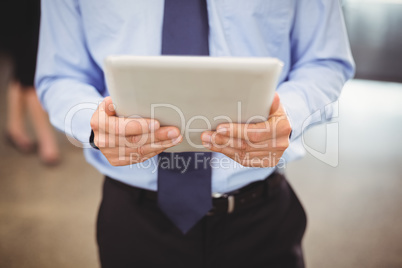 Mid section of businessman using digital tablet