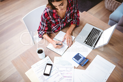 High angle view of woman writing in notepad