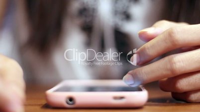 Soft focused girl's hands browsing smartphone