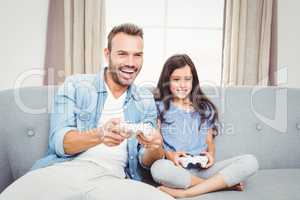 Father playing video game with daughter at home
