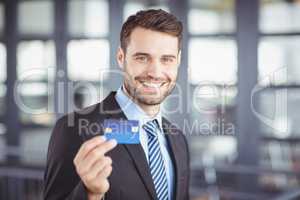 Happy businessman showing credit card