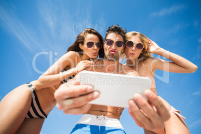 Happy friends taking selfie on the beach