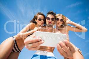 Happy friends taking selfie on the beach