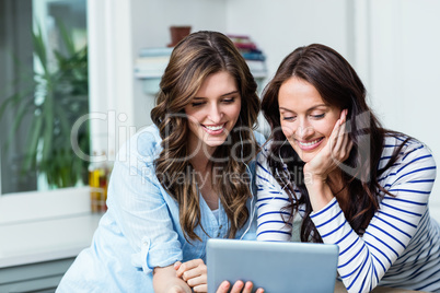 Smiling friends watching video on digital tablet