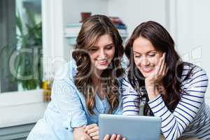 Smiling friends watching video on digital tablet