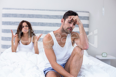 Man sitting while wife shouting at him