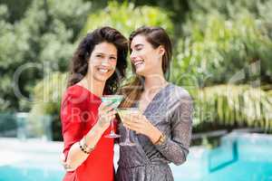 Young female friends drinking cocktail by during party