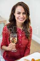 Portrait of cheerful woman holding white wine glass