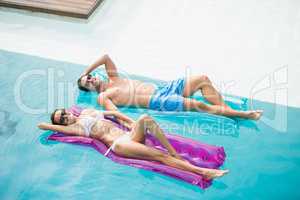 Smiling couple relaxing on inflatable raft